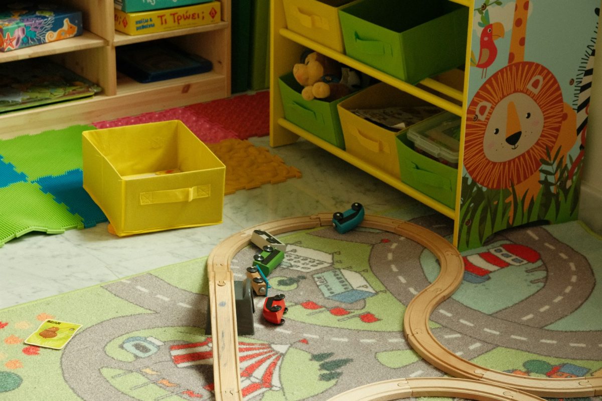 Spielecke im Kinderzimmer mit Spielteppich, Holzeisenbahn und Regal